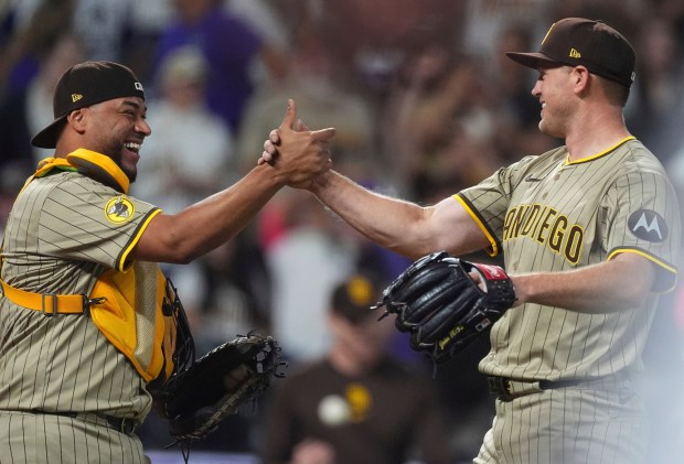 Padres catcher Elias Díaz congratulates starting pitcher Stephen Kolek after Kolek's complete game shutout against the Rockies on Saturday. (AP Photo/David Zalubowski)