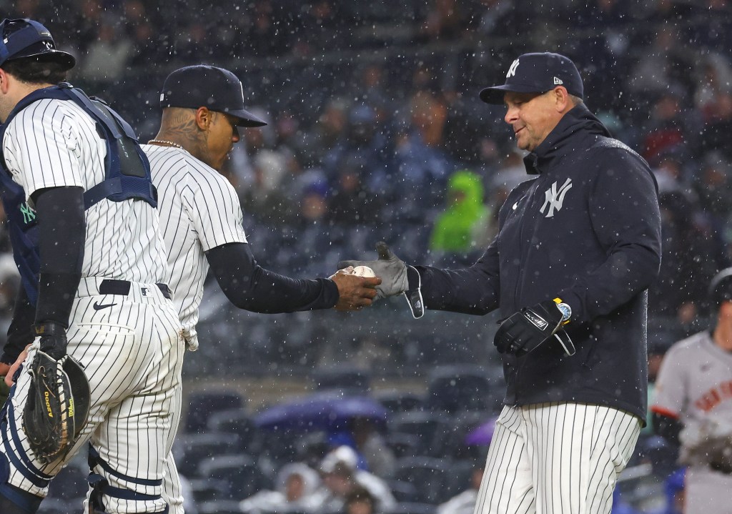 Yankees manager Aaron Boone (r.) takes the ball from Marcus Stroman (l.) during the first inning against the Giants on April 11, 2025.
