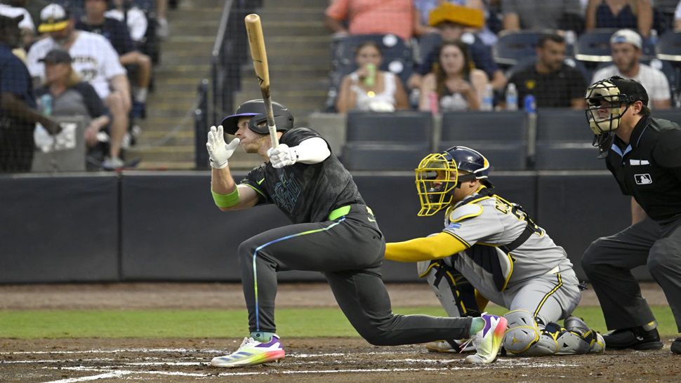 Tampa Bay Rays' Taylor Walls, left, hits a single during the third inning of a baseball game against the Milwaukee Brewers, Friday, May 9, 2025, in Tampa, Fla. (AP Photo/Jason Behnken)