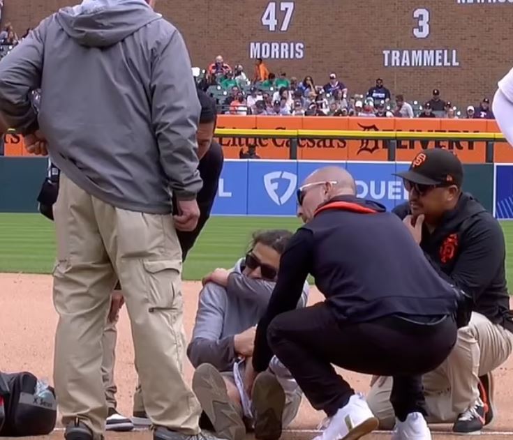 Tigers staff attending to an injured player on the field.