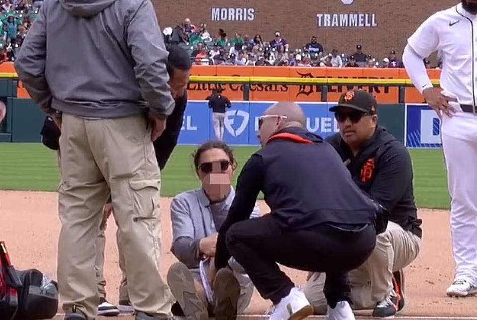 Tigers staff attending to an injured player on the field.