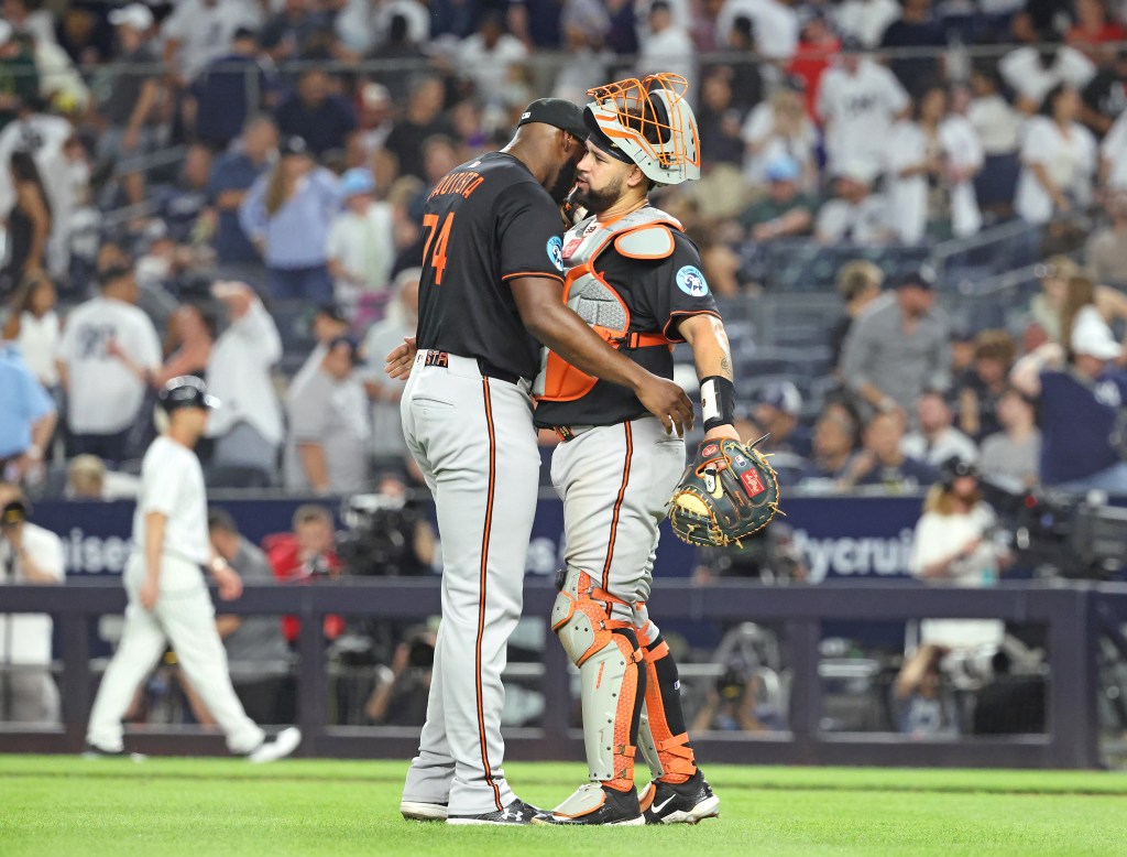 Baltimore Orioles pitcher Félix Bautista #74 hugs Baltimore Orioles catcher Gary Sánchez #99 after the final out of the 9th inning. 