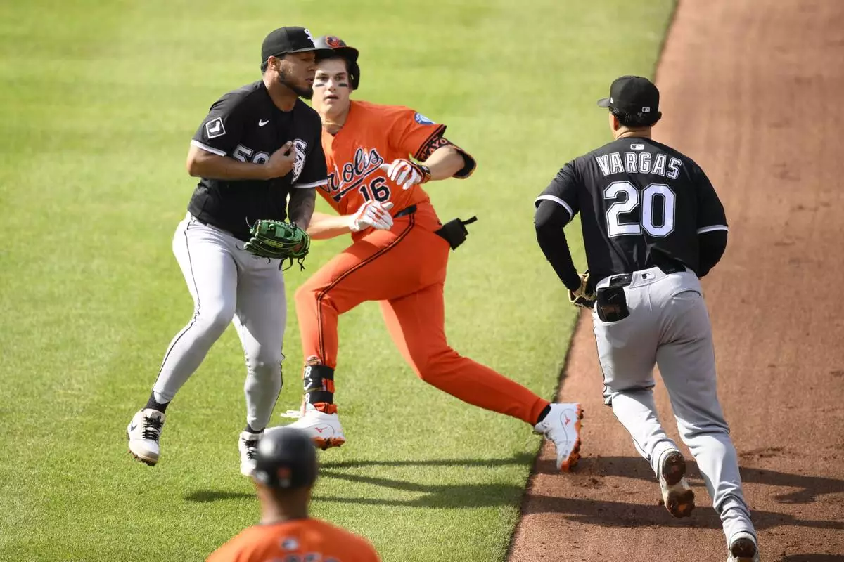 Baltimore Orioles' Coby Mayo (16) is caught in a rundown by Chicago White Sox first baseman Miguel Vargas (20) and second baseman Lenyn Sosa (50) during the fourth inning of a baseball game, Saturday, May 31, 2025, in Baltimore. (AP Photo/Nick Wass)