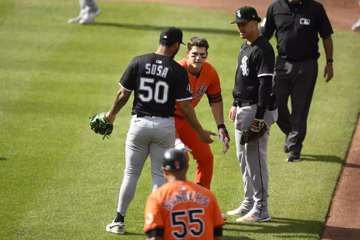 Chicago White Sox second baseman Lenyn Sosa (50) gestures to Baltimore Orioles' Coby Mayo, second from upper left, after Mayo was caught in a rundown during the fourth inning of a baseball game, Saturday, May 31, 2025, in Baltimore. (AP Photo/Nick Wass)