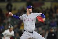 Texas Rangers pitcher Chris Martin (55) throws a pitch to an Athletics batter during the...