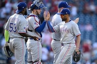 Texas Rangers' Marcus Semien, right, celebrates with Jonah Heim, center, and Adolis Garcia...