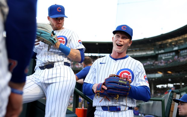 Cubs center fielder Pete Crow-Armstrong, right, and left fielder Ian Happ hang out on the edge of the dugout before taking the field for a game against the Brewers on Tuesday, June 17, 2025, at Wrigley Field. (Chris Sweda/Chicago Tribune)