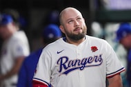 Texas Rangers first baseman Jake Burger reacts in the dugout after flying out for the final...