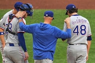 Texas Rangers pitcher Jacob deGrom (48) and catcher Jonah Heim (28) get a visit from...
