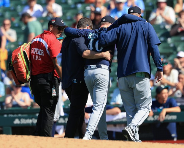 Mariners pitcher Trent Thornton is helped off the field after losing his balance in the eighth inning against the Cubs on June 21, 2025, at Wrigley Field. (John J. Kim/Chicago Tribune)