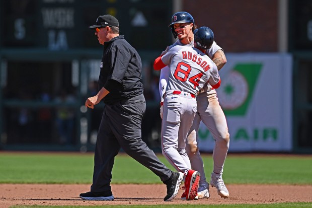 Boston Red Sox’s Jarren Duran (16) is held back by...