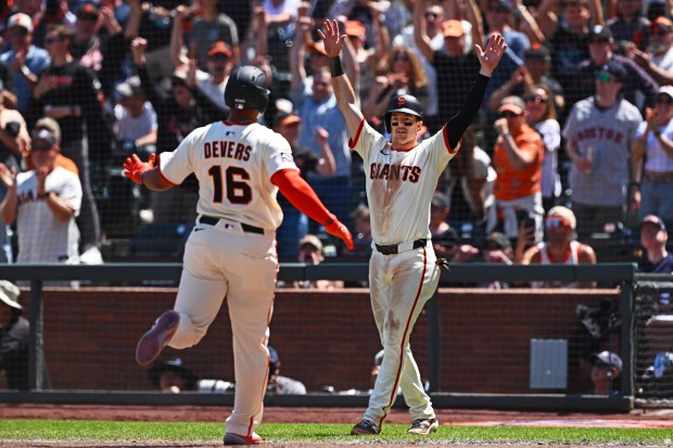 San Francisco Giants' Mike Yastrzemski (5) greets teammate Rafael Devers...