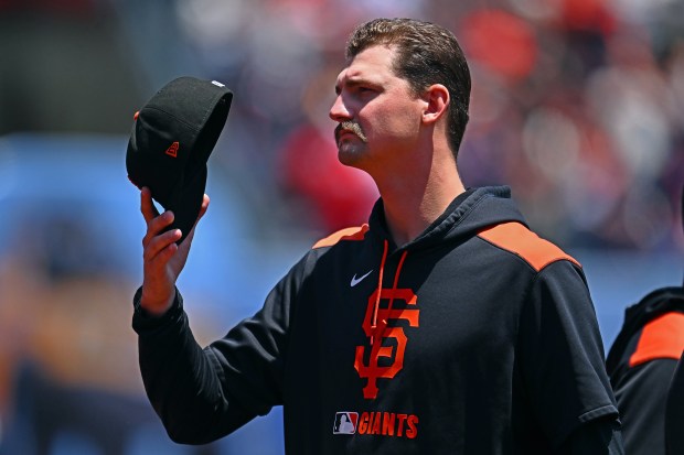 San Francisco Giants pitcher Sean Hjelle (64) removes his cap...