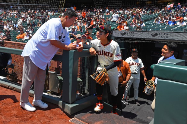 Former Korean baseball player Kim Tae-kyun, left, talks with San...