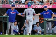 Texas Rangers' Marcus Semien (2) celebrates with the dugout after scoring during the fourth...