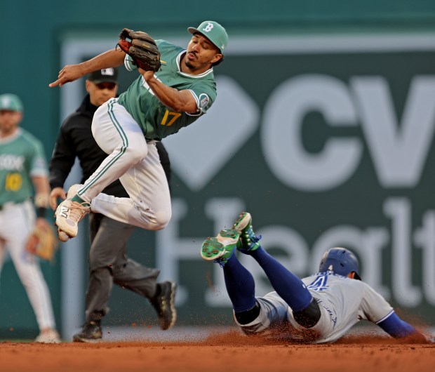 Boston Red Sox second base David Hamilton jumps over Toronto Blue Jays outfielder George Springer as he steals second in the third inning. (Staff Photo By Stuart Cahill/Boston Herald)