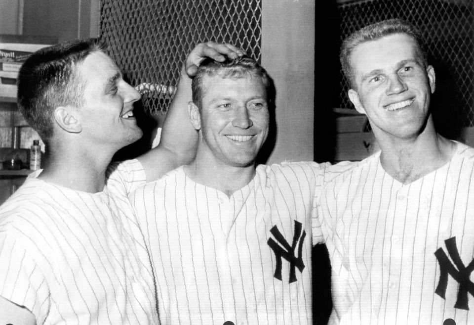 Black and white photo of Tony Kubek, Mickey Mantle, and Roger Maris celebrating a victory in the Yankee Stadium clubhouse.