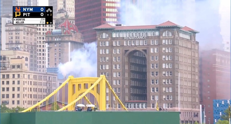 Screenshot of a baseball game with smoke rising near a bridge and the Renaissance Hotel.