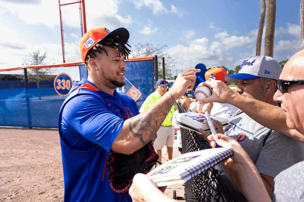 New York Mets pitcher Frankie Montas signing autographs at spring training.