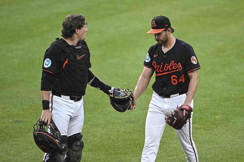 Baltimore Orioles pitcher Dean Kremer (64) is greeted by catcher Adley Rutschman, left, as they walk off the field during the third inning of a baseball game against the Detroit Tigers in Baltimore, Thursday, June 12, 2025. (AP Photo/Terrance Williams)