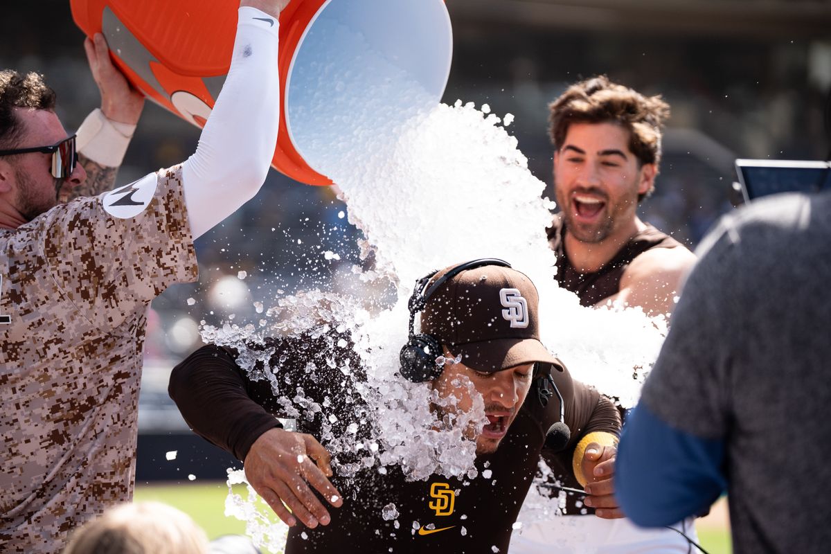 San Diego Padres players Jackson Merrill (3) and Tyler Wade (14) dump water on José Iglesias (7) after a walk-off win against the Kansas City Royals on June 22, 2025 at Petco Park in San Diego, CA.