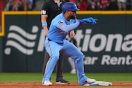 Texas Rangers' Ezequiel Duran, front, stands on second base and reacts after hitting a...