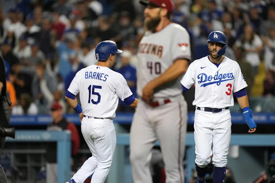 Los Angeles Dodgers catcher Austin Barnes (15) celebrates with designated hitter Chris Taylor (3) after scoring in the fifth inning as Arizona Diamondbacks starting pitcher Madison Bumgarner (40) reacts at Dodger Stadium.Kirby Lee-Imagn Images