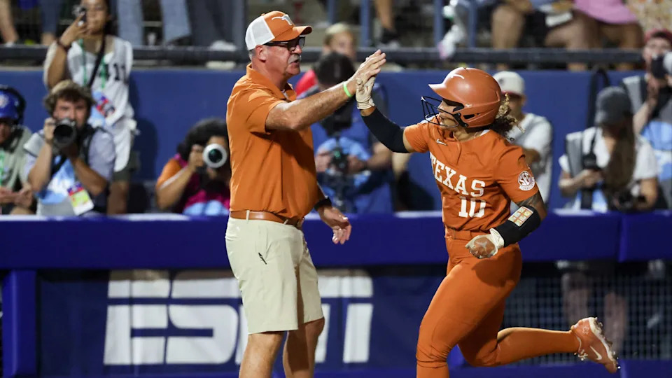 OKLAHOMA CITY, OKLAHOMA - JUNE 05: Head coach Mike White and Mia Scott #10 of the Texas Longhorns high five after Scott's in the sixth inning during game two of the Women's College World Series championship series against the Texas Tech Red Raiders at USA Softball Hall of Fame Stadium on June 05, 2025 in Oklahoma City, Oklahoma. (Photo by Ian Maule/Getty Images)