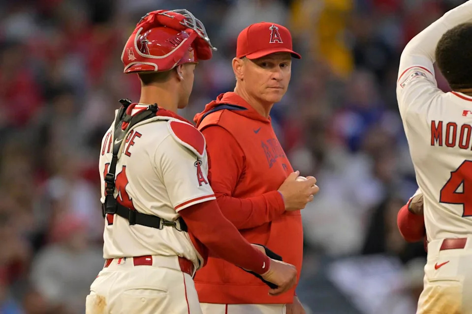 Angels interim manager Ray Montgomery, second from left, waits on the mound with catcher Logan O'Hoppe.