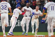 Texas Rangers' Adolis García, center, celebrates with Jake Burger (21), Wyatt Langford,...