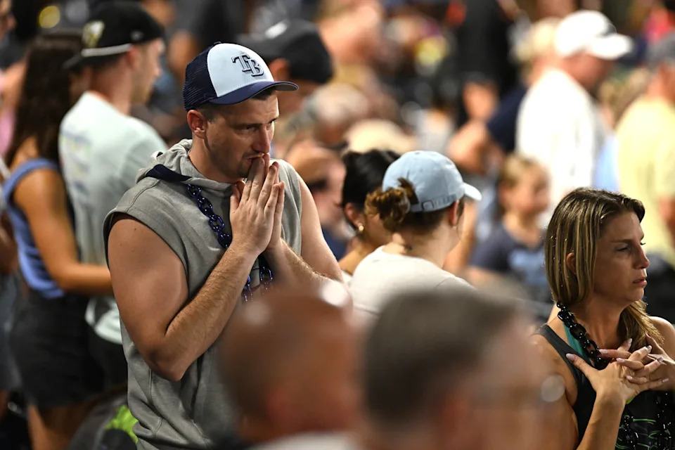 Tampa Bay Rays fans look on as pitcher Hunter Bigge (43) gets medical attention after getting hit in the face by a foul ball.