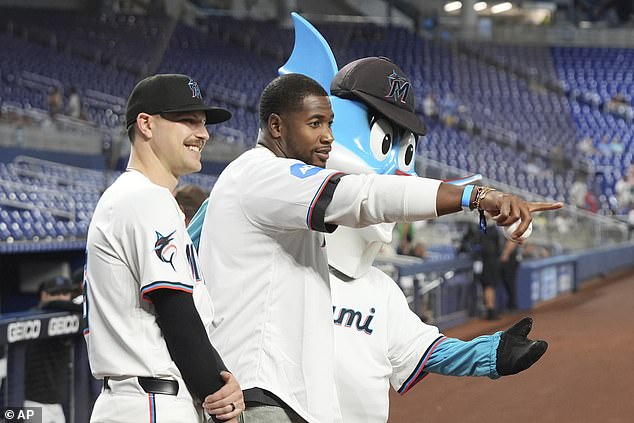Miami Dolphins tight end Jonnu Smith (center) and the Marlins' Janson Junk are seen at the near-empty game
