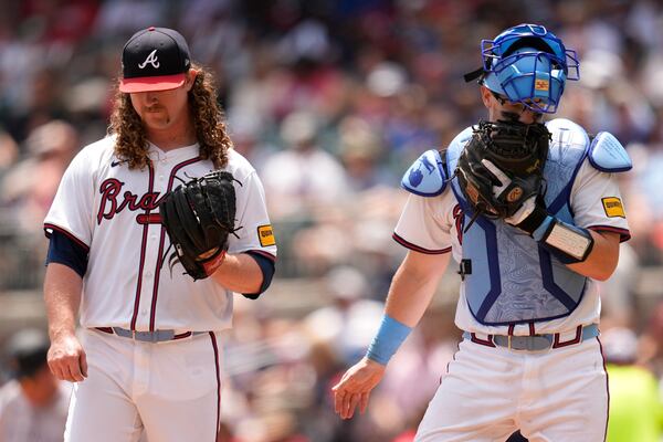 Braves pitcher Grant Holmes (left) talks to catcher Sean Murphy during the sixth inning of Sunday's loss to the Rockies. (Mike Stewart/AP)