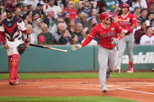 Angels star Mike Trout tosses his bat as he watches...