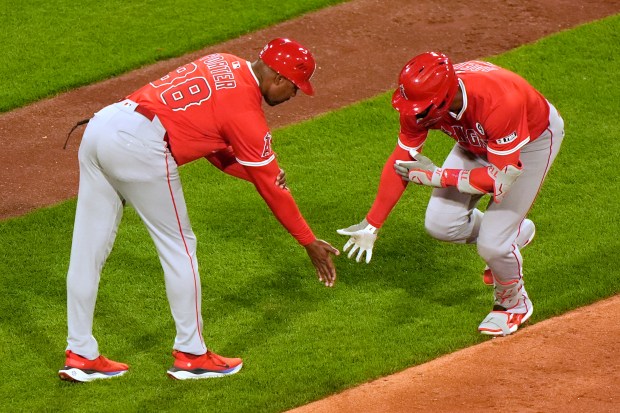 The Angels’ Jo Adell, right, is congratulated by third base...