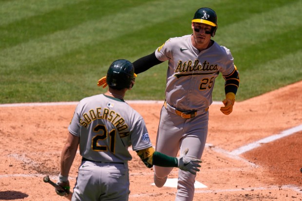 The Athletics’ Brent Rooker, right, is congratulated by teammate Tyler...