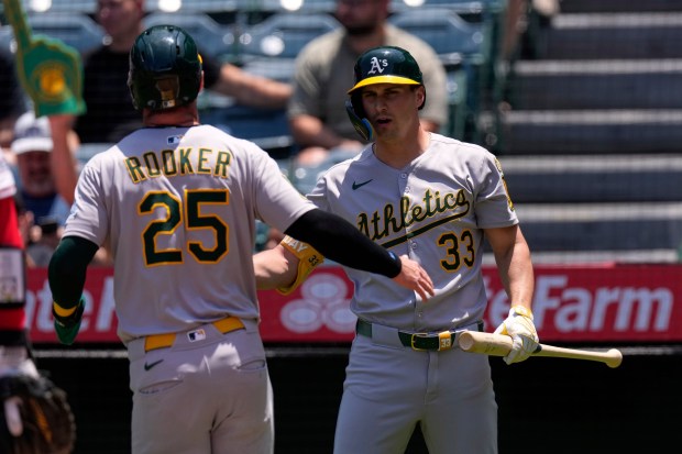 The Athletics’ Brent Rooker, left, is congratulated by teammate JJ...