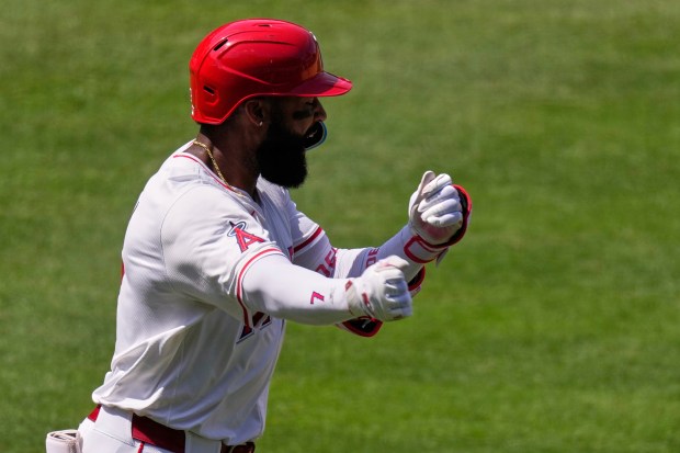 The Angels’ Jo Adell celebrates as he begins to run...