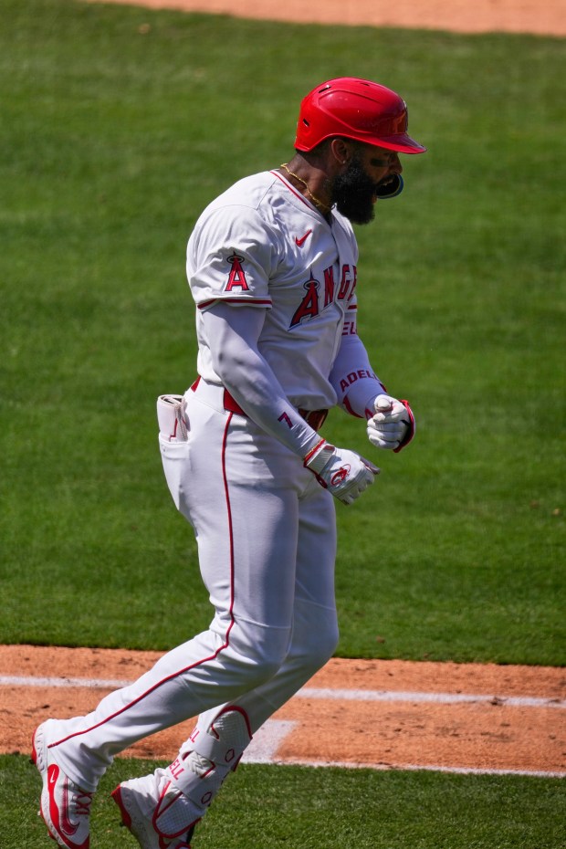 The Angels’ Jo Adell celebrates as he begins to run...