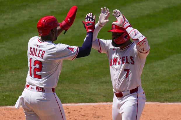 The Angels’ Jo Adell, right, is congratulated by Jorge Soler...