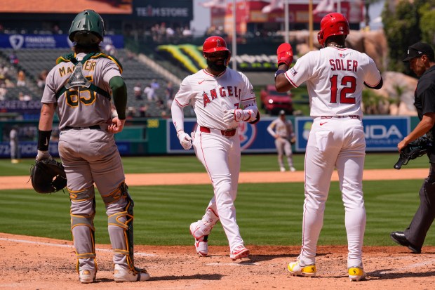 The Angels’ Jo Adell, center, is congratulated by Jorge Soler,...