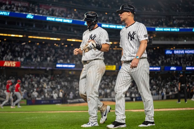 New York Yankees players walk off the field after their...