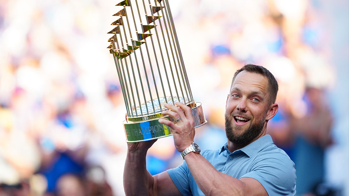 Former Kansas City Royals outfielder Alex Gordon holds up the 2015 World Series trophy during the retirement ceremony for Lorenzo Cain prior to a game against the Oakland Athletics at Kauffman Stadium.
