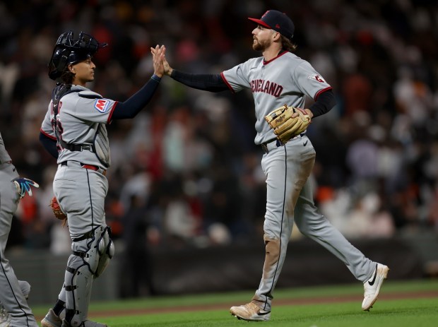 Cleveland Guardians’ Daniel Schneemann #10 and catcher Bo Naylor #23...