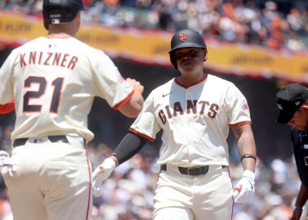 San Francisco Giants designated hitter Rafael Devers #16 is congratulated...