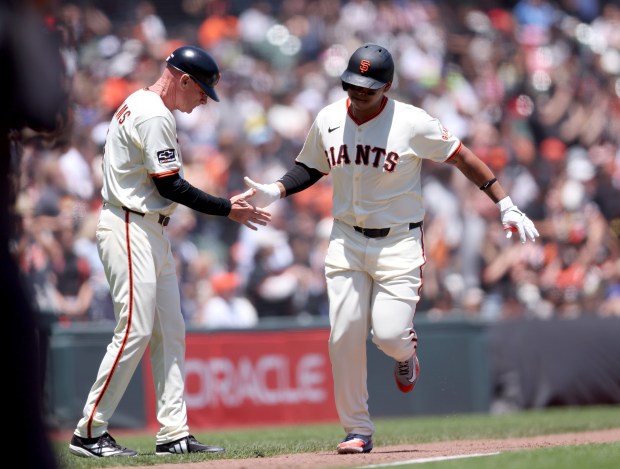 San Francisco Giants designated hitter Rafael Devers #16 is congratulated...
