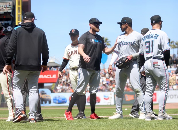 Miami Marlins bench coach Carson Vitale, center, tries to clear...