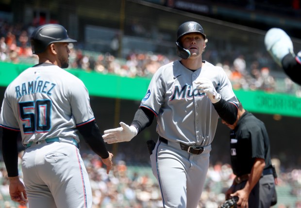 Miami Marlins' Kyle Stowers #28 is congratulated by teammate Agustín...