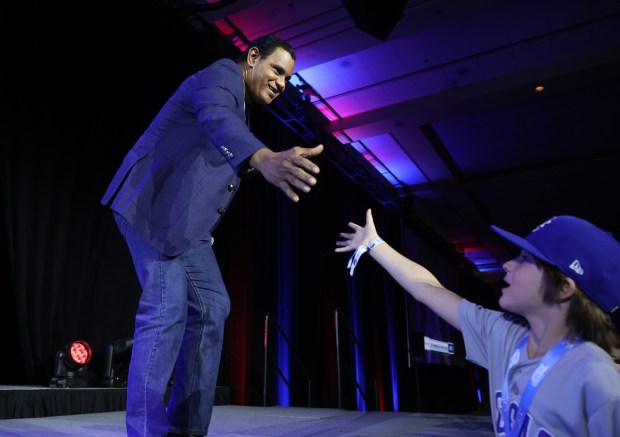 Former Cubs player Sammy Sosa greets a fan as he...