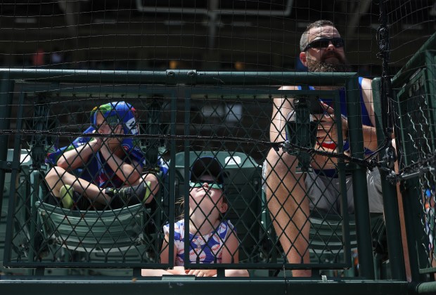 Aaron Weakley sits next to his children, Arlo, 5, left, and Ameila, 4, before a Cubs-Mariners game on June 21, 2025, at Wrigley Field. (John J. Kim/Chicago Tribune)